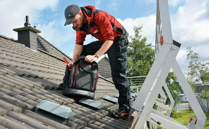 Foto eines Monteurs von Seilsicherungen zum Schutz gegen Absturz vom Dach